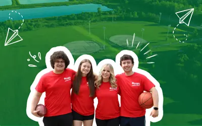 camp councilors in red shirts in front of green background with semi-transparent aerial photo of ball diamonds