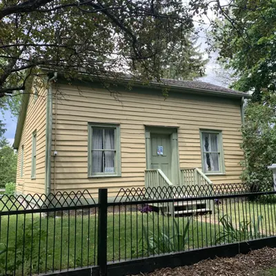 yellow house with black fencing surrounding it