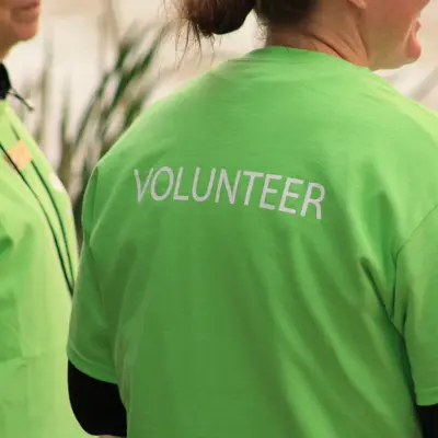 back of green shirt with the word volunteer